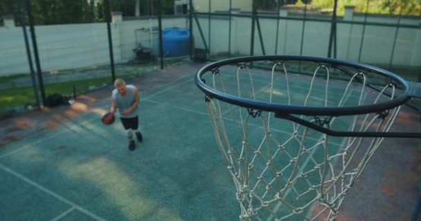 Männliche Basketballspieler beim Training auf dem Platz. Coole Kerle springen und werfen Ball in Reifen. Zielkonzept — Stockvideo