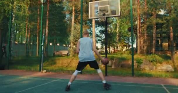 Basketballprofi coole junge Kerl Training Score Ball in Reifen im Freien vor Gericht — Stockvideo