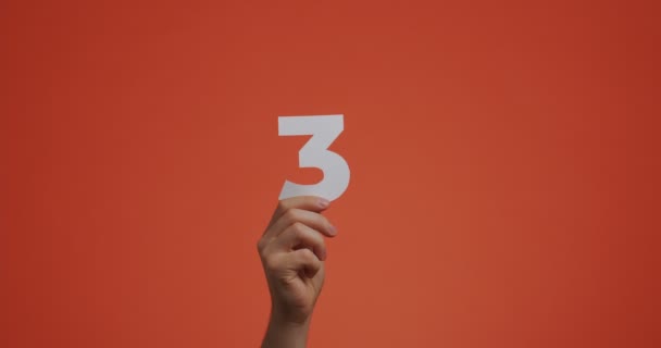 手札の数字3 。腕に数字、ブログ、投票や学習のための刻まれた紙で作られた3番目の数字 — ストック動画