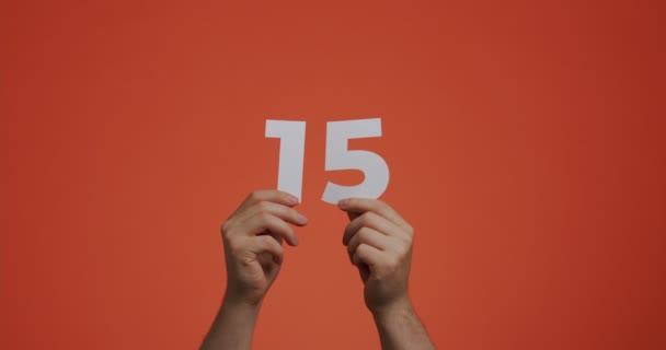 Number fifteen in hands. Man showing digits, 15 made of carved paper for voting or mathematics learning — Vídeo de Stock