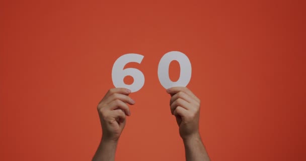 Number sixty in hands. Man showing digits, 60 made of carved paper for voting or mathematics learning — Vídeo de Stock