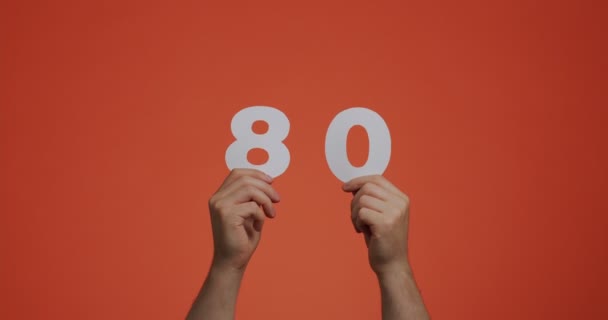 Number eighty in hands. Man showing digits, 80 made of carved paper for voting, mathematics learning or sale — Vídeo de Stock