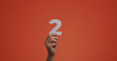 İki numarayı gösteriyor. Rakamlı kol, blog, oy verme, mağaza satışı için oyulmuş kağıttan yapılmış ikinci numara.