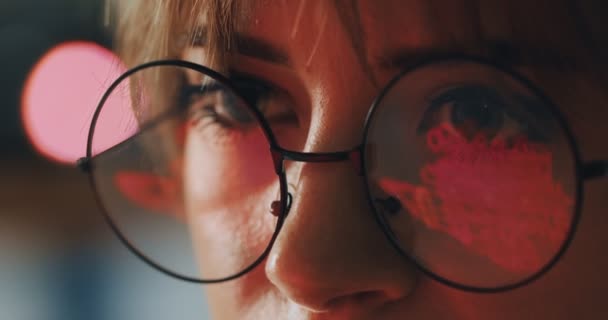 Närbild ögon i glasögon av kvinnliga designer skapare tittar på skärmen, arbetar online på kontoret. — Stockvideo