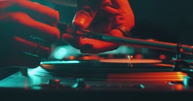 DJ müzik çalıyor, siyah vinil plağa iğne takıyor parti performansı sırasında DJ pikabında dönüyor, yakın plan.