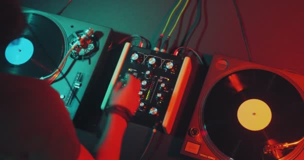 DJ přehrávání elektronické hudby na regulátoru dj mixer stůl, dotýkání jezdců v nočním klubu party, pohled shora — Stock video