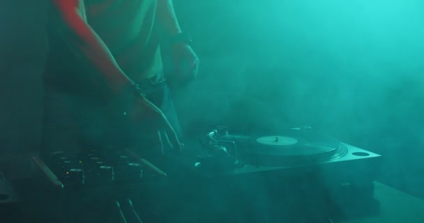 Deejay tourne des disques sur une platine dansant en fumée dans une boîte de nuit. Dj performer sur la fête, la musique électronique moderne rave — Video