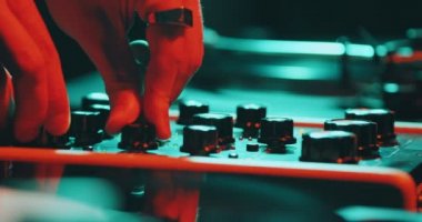 Partide DJ operasyon masası, kapatın. Erkek DJ elleri gece kulübünde renkli ışıkta parti sırasında müzik çalıyor.