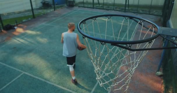 Cooler Typ amerikanischer Basketballer wirft Ball ins Hoop-Training auf dem Platz — Stockvideo