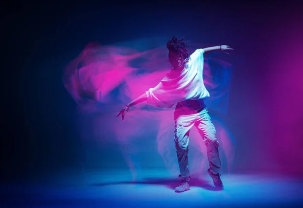 Chica moderna bailando con estilo que se mueve en la luz colorida estudio de neón. Larga exposición. Copiar espacio —  Fotos de Stock