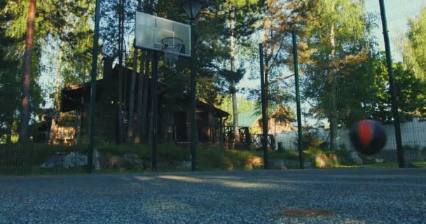 Bola de basquete saltar rolando no campo de basquete chão ao ar livre no verão. Conceito de treino ao ar livre — Vídeo de Stock