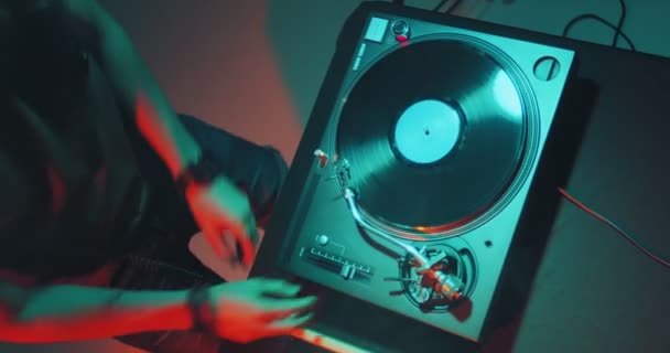 Dj memainkan musik elektronik di meja kontroler mixer di pesta klub malam. Deejay tangan menyentuh vinyls, sliders. Tampilan atas — Stok Video