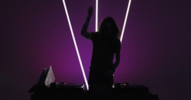 DJ gece kulübünde sahne alacak, mikser kontrolöründe dans edecek, parti verecek. Karanlıktaki DJ silueti. Gece hayatı.