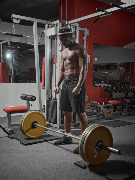 Le sportif afro-américain s'entraîne avec des haltères et des poids en salle de gym. Haltérophilie, entraînement de force — Photo