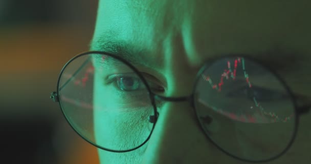 Homme d'affaires travaillant la nuit en regardant le moniteur, réflexions dans les lunettes du trader boursier apprentissage graphique de la monnaie — Video