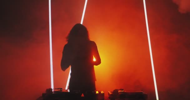 Silhouette of dancing deejay young guy rocking party up in red light in smoke in nightclub. Nightlife concept — Stock Video