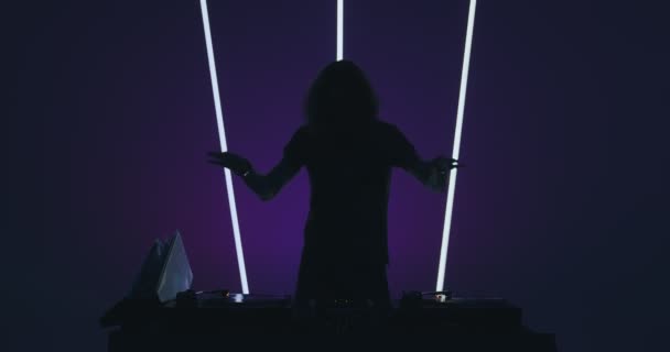 Tanzender DJ, der in einem Nachtclub auflegt und coole zeitgenössische Musik an der DJ-Konsole spielt. Nachtleben-Konzept — Stockvideo