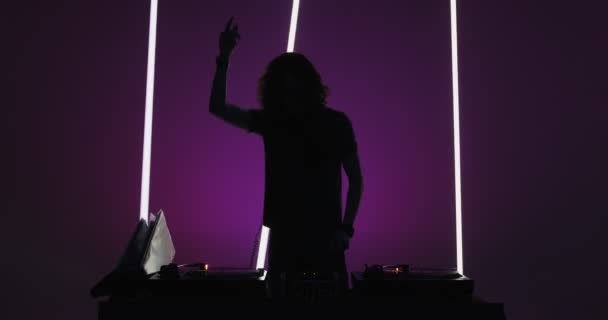 Silhouette of Dj performing, dancing at mixer controller, rocking party up in nightclub. Nightlife concept — Stock Video