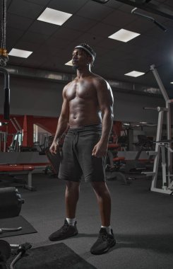 Eğitim sırasında spor salonunda çıplak kaslı poz veren Afrikalı Amerikalı bir adam. Spor sağlıklı yaşam tarzı