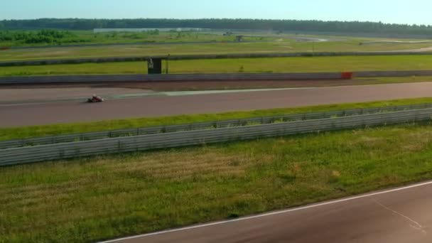 Zawody kart racing latem w złotej godzinie. Obraz z lotu ptaka. Karty poruszające się po torze wyścigowym — Wideo stockowe