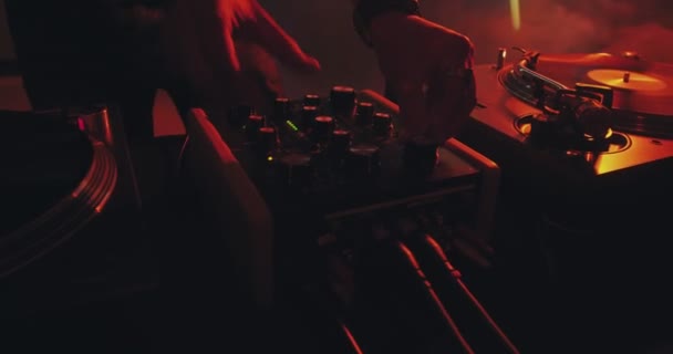 Console de contrôle sonore DJ pour mixer de la musique de danse dans un club disco. curseurs touchants des mains, lecture de musique électronique, gros plan — Video