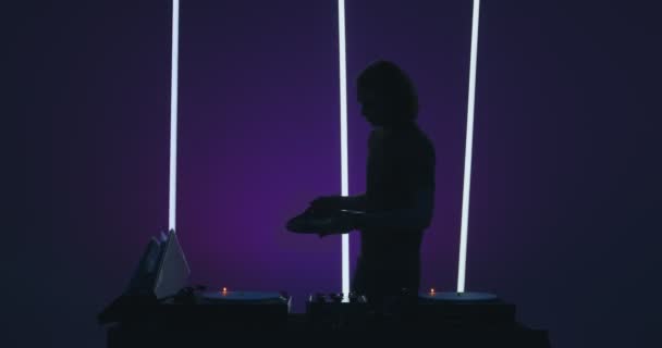 Silhouette de DJ masculin moderne jouant des vinyles à la console dj dans une boîte de nuit. Vie nocturne et fête — Video