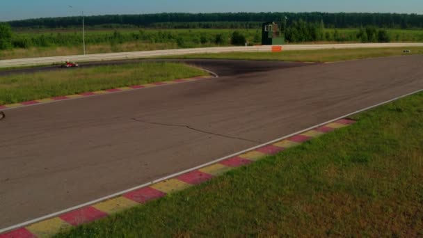Pista de Karting, vista aérea. Carrera de karts rápido alrededor de las curvas en verano en la hora dorada — Vídeos de Stock