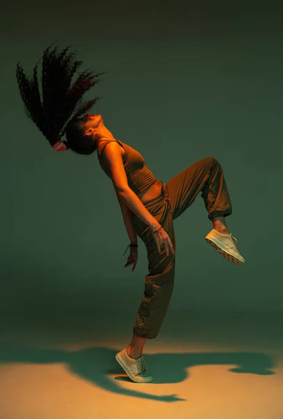 Taniec atletyczny mieszany wyścig dziewczyna wykonując ekspresyjny ognisty hip hop lub etniczny nowoczesny taniec w świetle studio — Zdjęcie stockowe