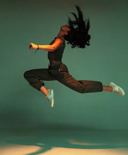 Dancing mixed race young girl jumping with waving hairs. Female dancer performer show expressive hip hop dance — Stock Photo, Image