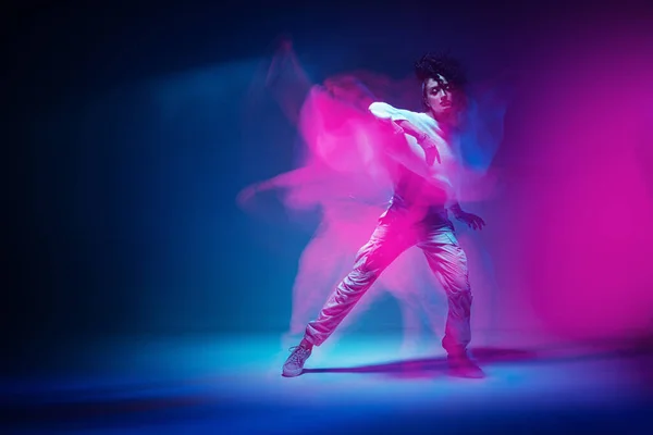 Taniec mieszany wyścig dziewczyna w kolorowe neonowe światło studio. Tancerka pokazała ekspresyjny taniec hip-hopowy. Długotrwałe narażenie — Zdjęcie stockowe