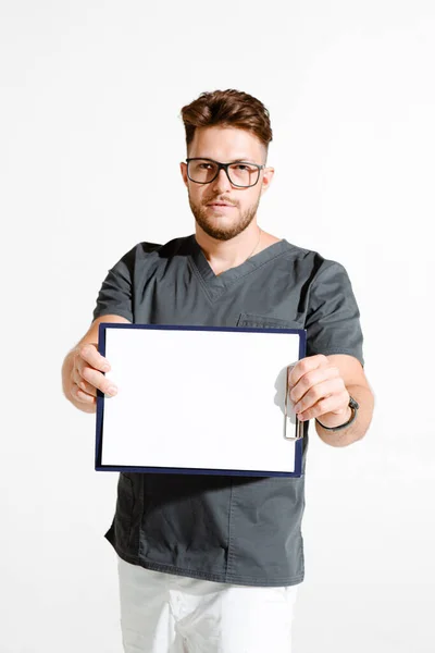 안경을 쓴 남성 주치의 가병원 광고를 위해 흰색 배경에 빈 칸 이 있는 표지판을 보여 주고 있다 — 스톡 사진