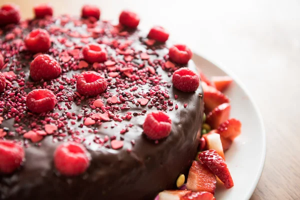 Schokoladenkuchen mit Himbeeren und Erdbeerscheiben Stockfoto