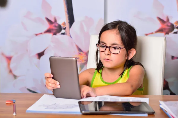 Niña usando un Tablet PC y un Ebook para la tarea —  Fotos de Stock