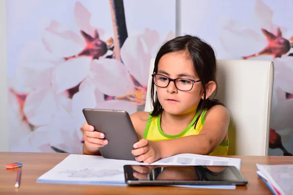 Kleines Mädchen mit Tablet-PC und E-Book für die Hausaufgaben — Stockfoto