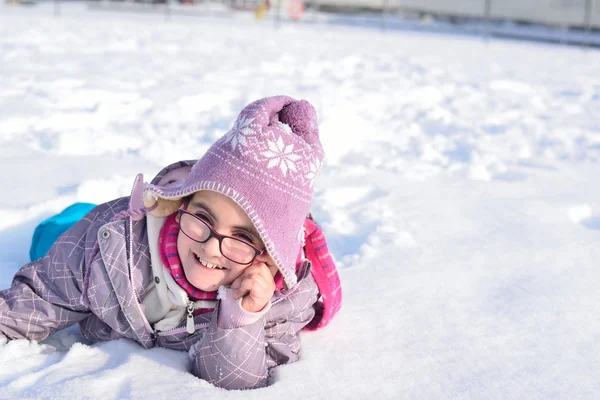 Little girl with glasses playing in the snow — Stock Photo, Image