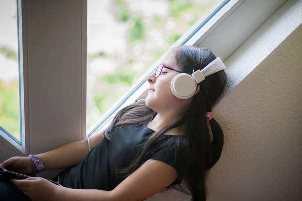 Cute girl with glasses listening to music — Stock Photo, Image