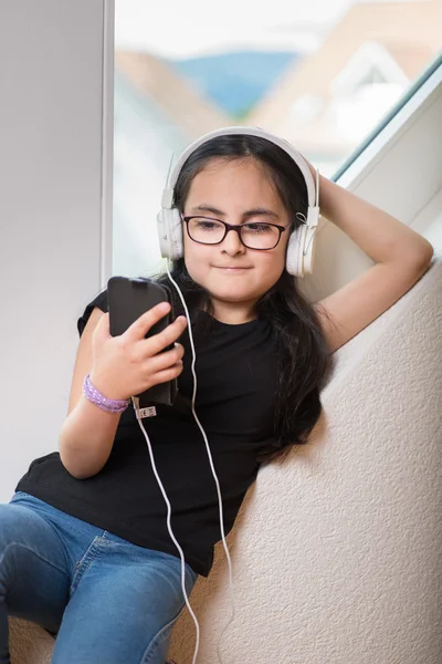 Menina bonito com óculos ouvindo música — Fotografia de Stock