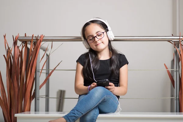 Menina bonito com óculos ouvindo música — Fotografia de Stock