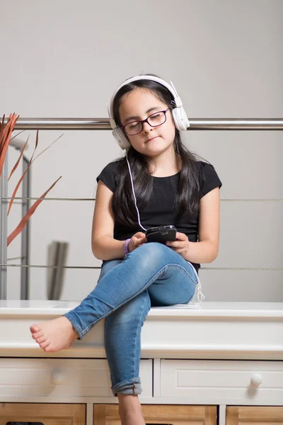 Menina bonito com óculos ouvindo música — Fotografia de Stock