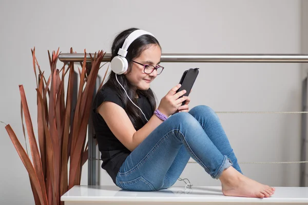 Menina bonito com óculos ouvindo música — Fotografia de Stock