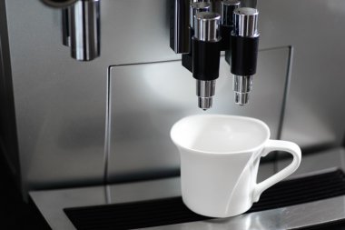 Kahve makinesi ve bir fincan kahve