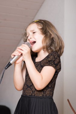 Üzerinde bir mikrofon şarkı söyleyen kız
