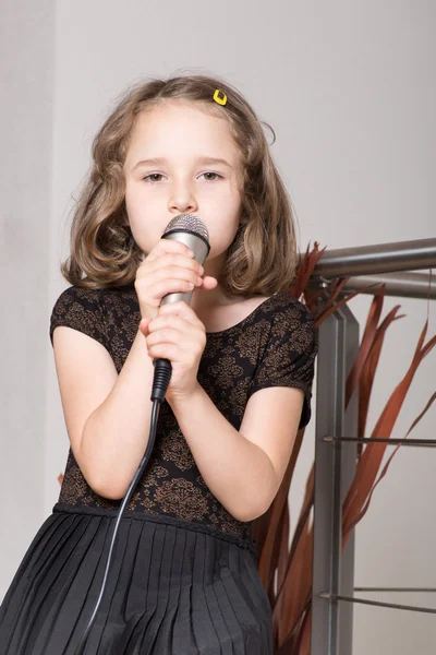 Girl singing on a microphone — Stock Photo, Image