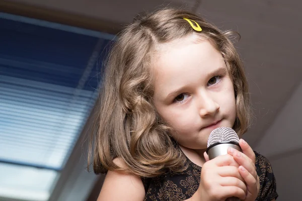 Girl singing on a microphone — Stock Photo, Image