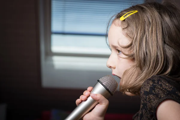 Girl singing on a microphone — Stock Photo, Image