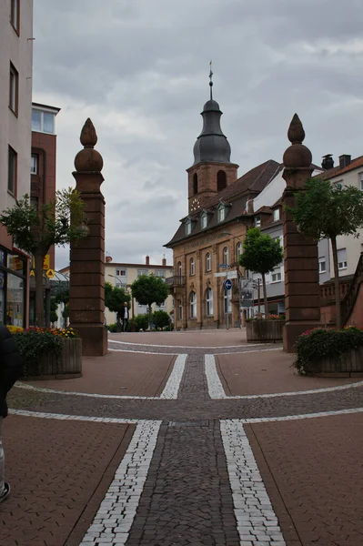 Hauptstrasse 'deki sütunlar, Pirmansens, Almanya' nın ana caddesi. Lüteriyen 'de bir binanın arkasında kulesi var..