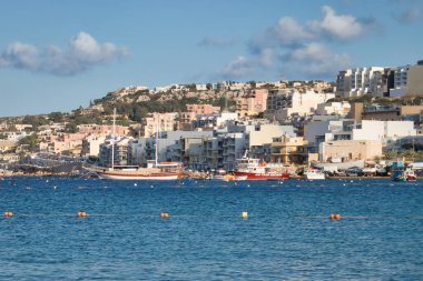 Mellieha Körfezi 'nin güzel mavi suları Malta' nın Mellieha şehrinin arka planında bir tepe üzerindedir..