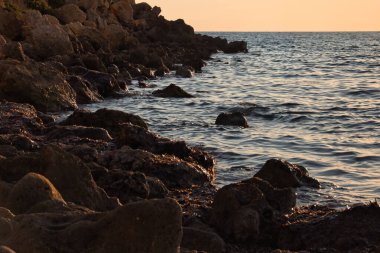 Malta 'da gün batımında Golden Bay sahilinde kayalar..