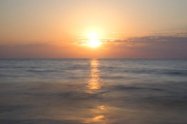 Golden Bay, Malta 'da okyanusun üzerinde güzel renkli gün batımı.