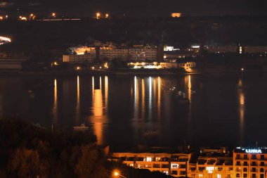 Malta 'nın Mellieha şehrinde gece vakti yapılan bina ve yansıma..